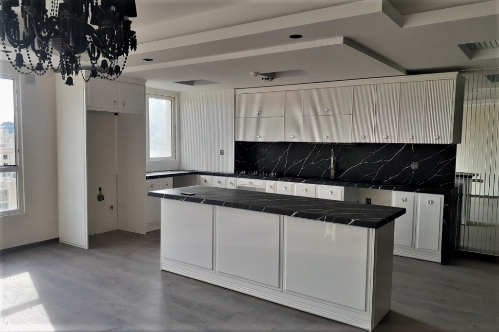 A kitchen with white cabinets and black counter tops

Description automatically generated