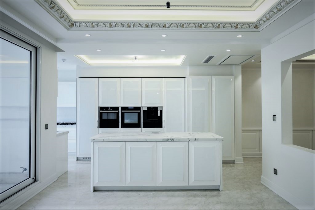 A kitchen with white cabinets and a white countertop

Description automatically generated