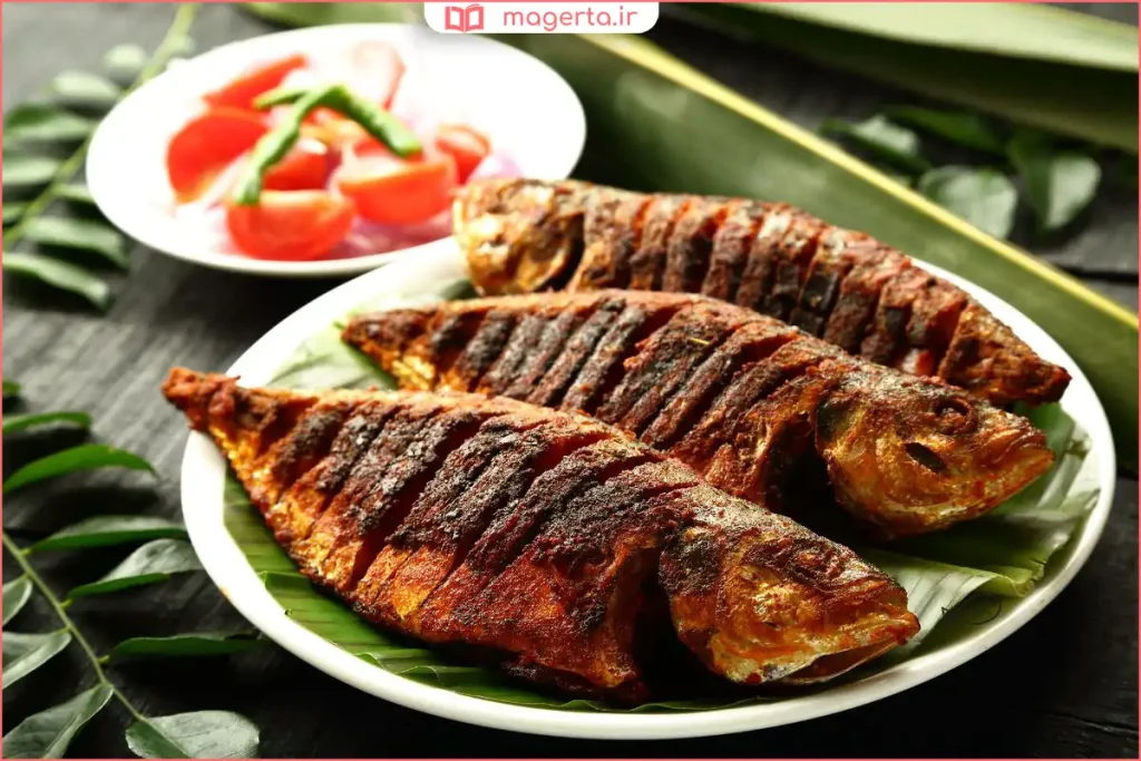 ماهی کبابی گریلشده روی ذغال همراه با لیمو و سبزیجات تازه