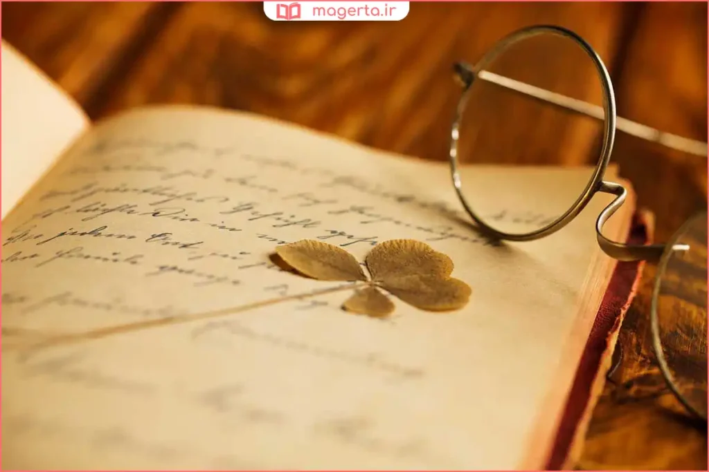 نمای نزدیک از کتاب شعر بازشده روی میز مطالعه