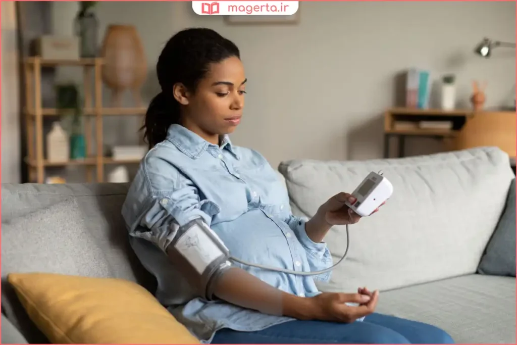 مادر باردار در حال اندازهگیری فشار خون با دستگاه دیجیتال در خانه