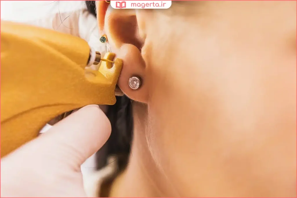 پرستار در حال سوراخ کردن گوش نوزاد با دستگاه استریل در کلینیک