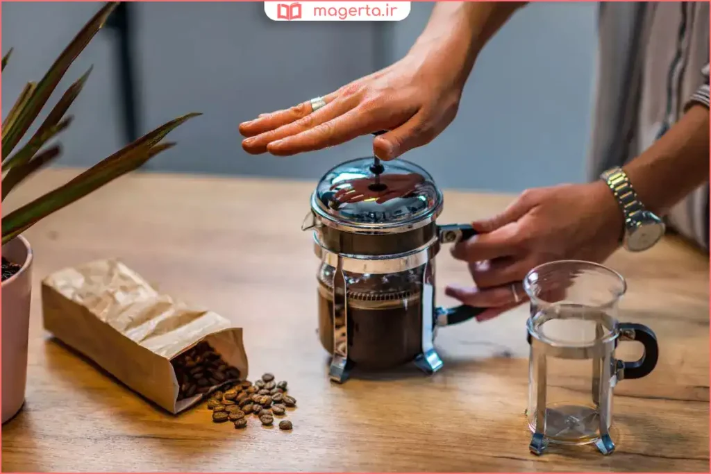 دم کردن قهوه تازه آسیابشده در قهوهساز دستی روی میز چوبی