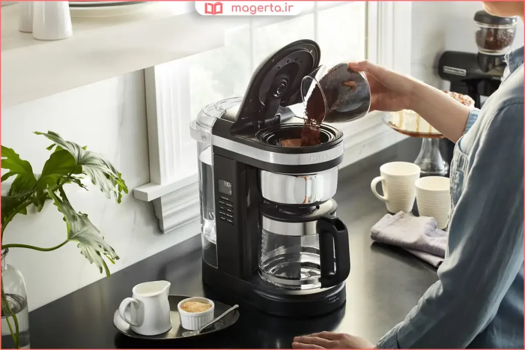 افزودن پودر قهوه به فیلتر مخصوص در دستگاه قهوه‌ساز خانگی