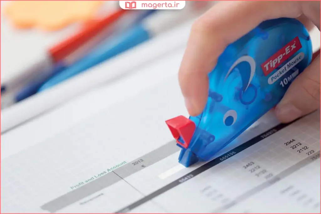 دست در حال کشیدن غلطگیر نواری روی خط اشتباه در دفتر یادداشت