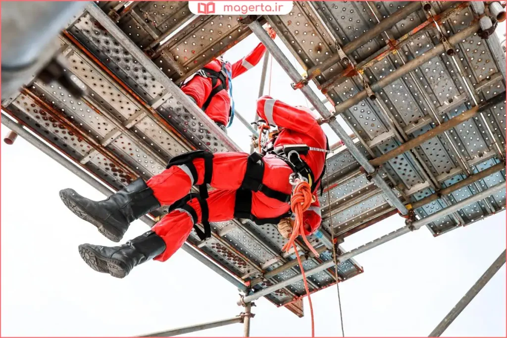 کارگر صنعتی در حال استفاده از طناب کوهنوردی برای کار در ارتفاع