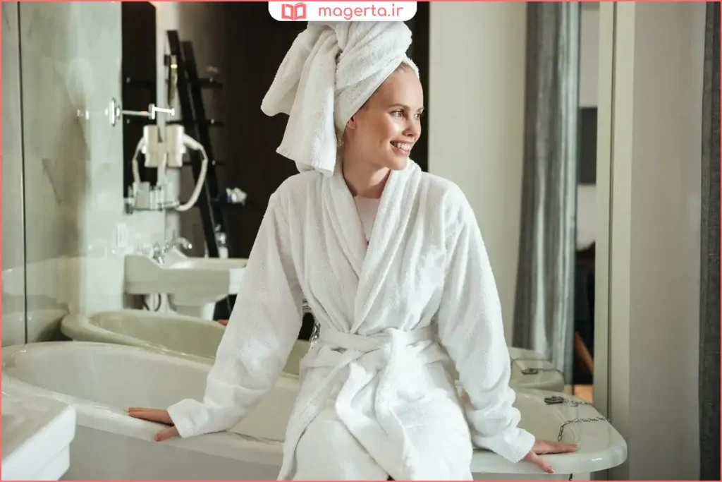 حوله تنپوش زنانه سفید نرم آویزان روی رختآویز حمام