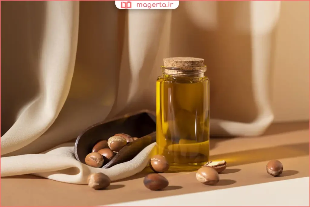 بطری روغن آرگان طبیعی کنار برس چوبی و حوله سفید