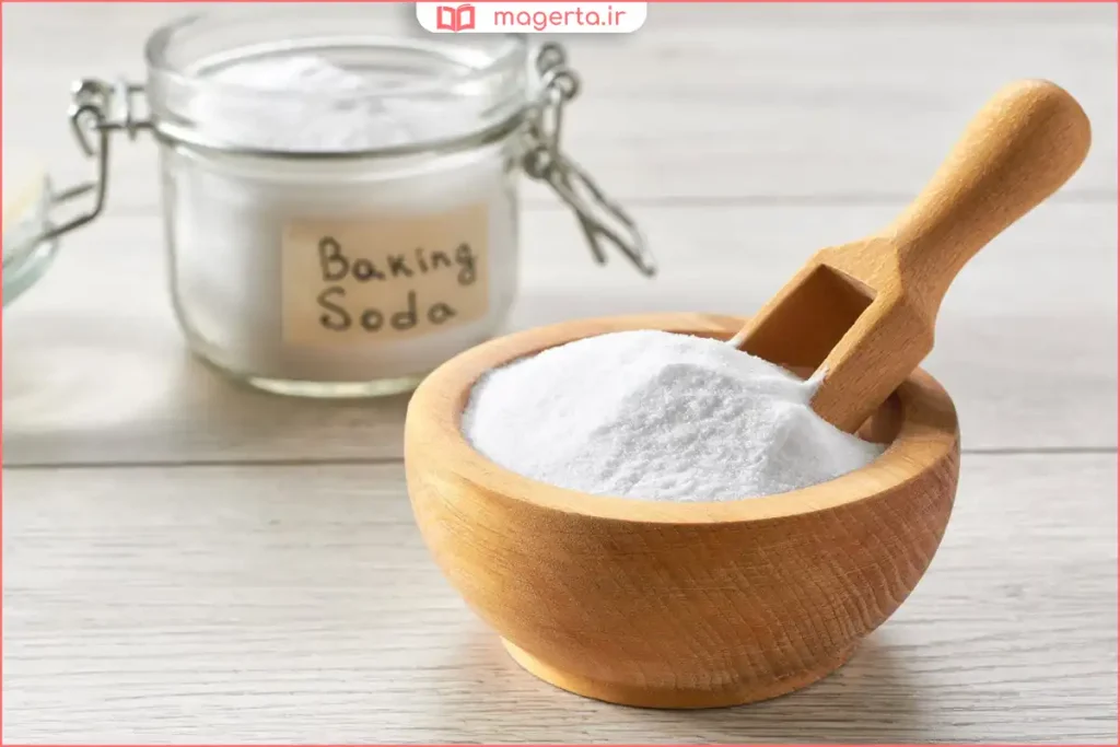 پودر جوش شیرین سفید در ظرف شیشه‌ای روی سطح آشپزخانه