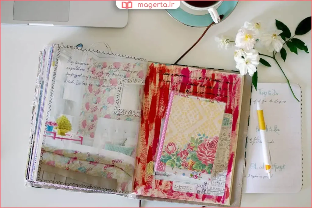 دفتر ژورنال باز روی میز با خودکار و یادداشت‌های شخصی