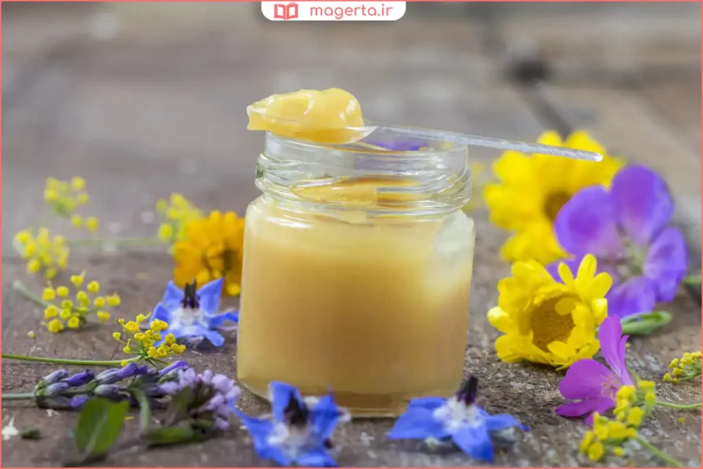 نمای نزدیک از ژل رویال سفید شیری در قاشق چوبی