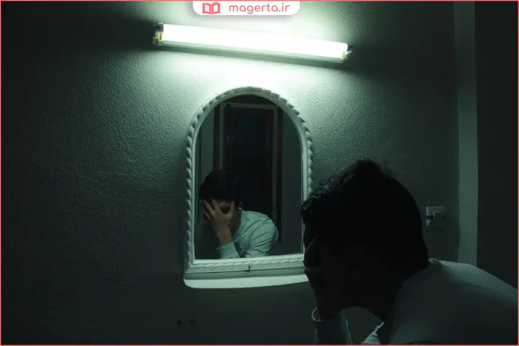 فردی تنها با دست روی صورت نشانه خودسرزنشی و نارضایتی درونی