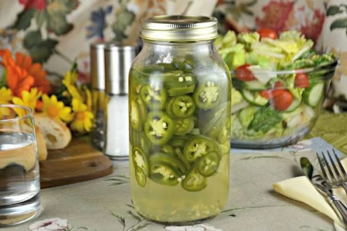 ریختن سرکه سفید روی فلفل برای تهیه ترشی